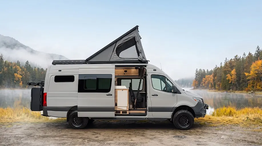 The same Parbat beside a misty lake in autumn, rooftop tent raised and the sliding door open on the interior