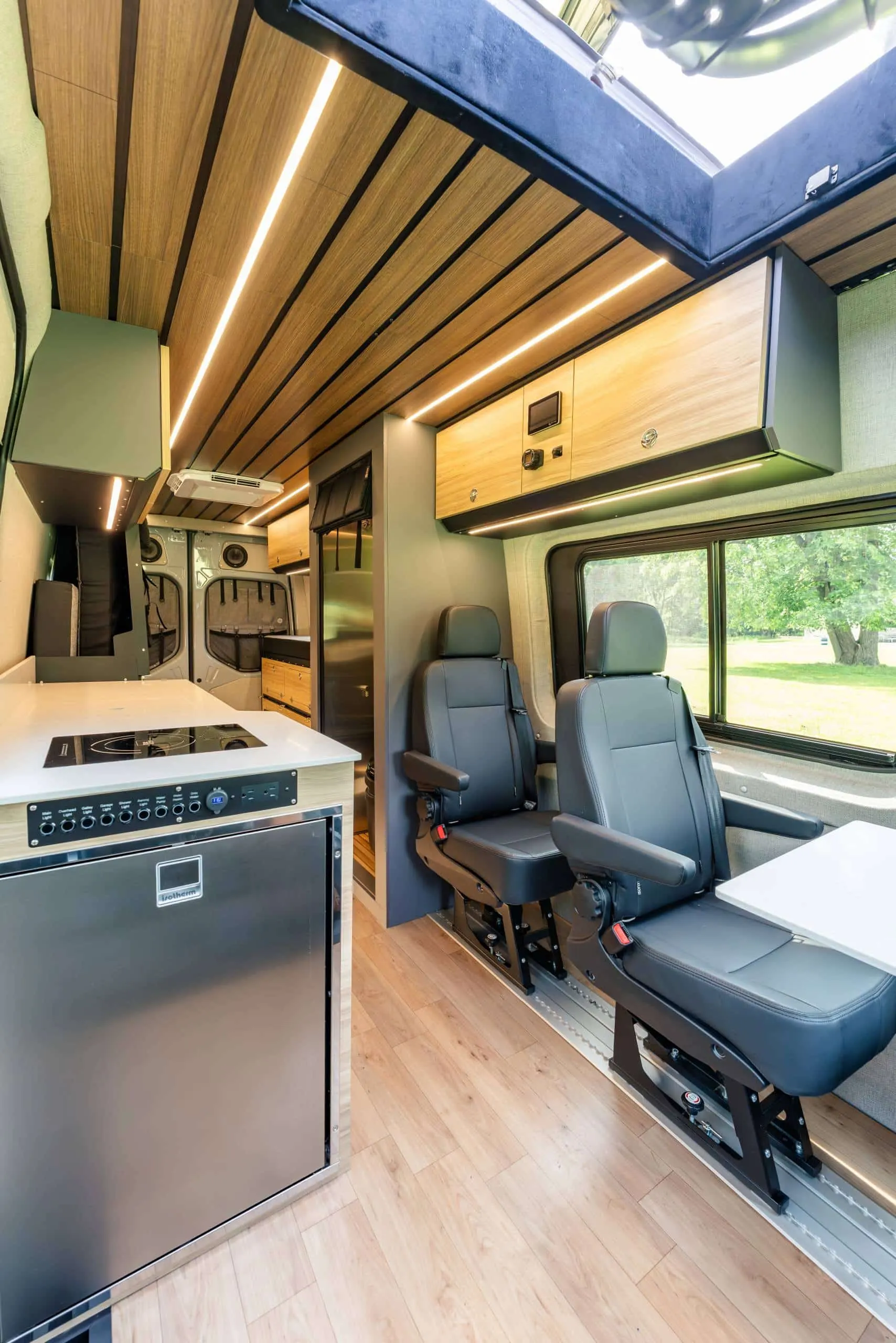 Parbat galley with the fridge and cooktop, seats and a wood floor
