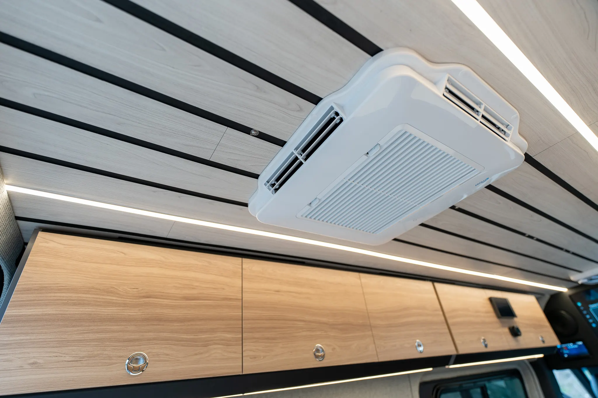 Low-profile air conditioner set into the slatted ceiling above the overhead cabinet run