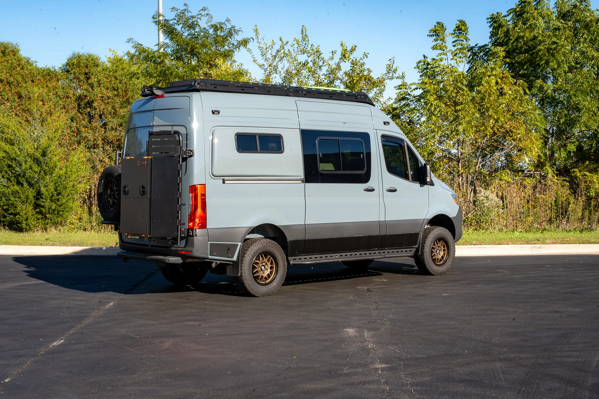 The passenger side, three-quarter view from the rear, with the tire carrier and storage box