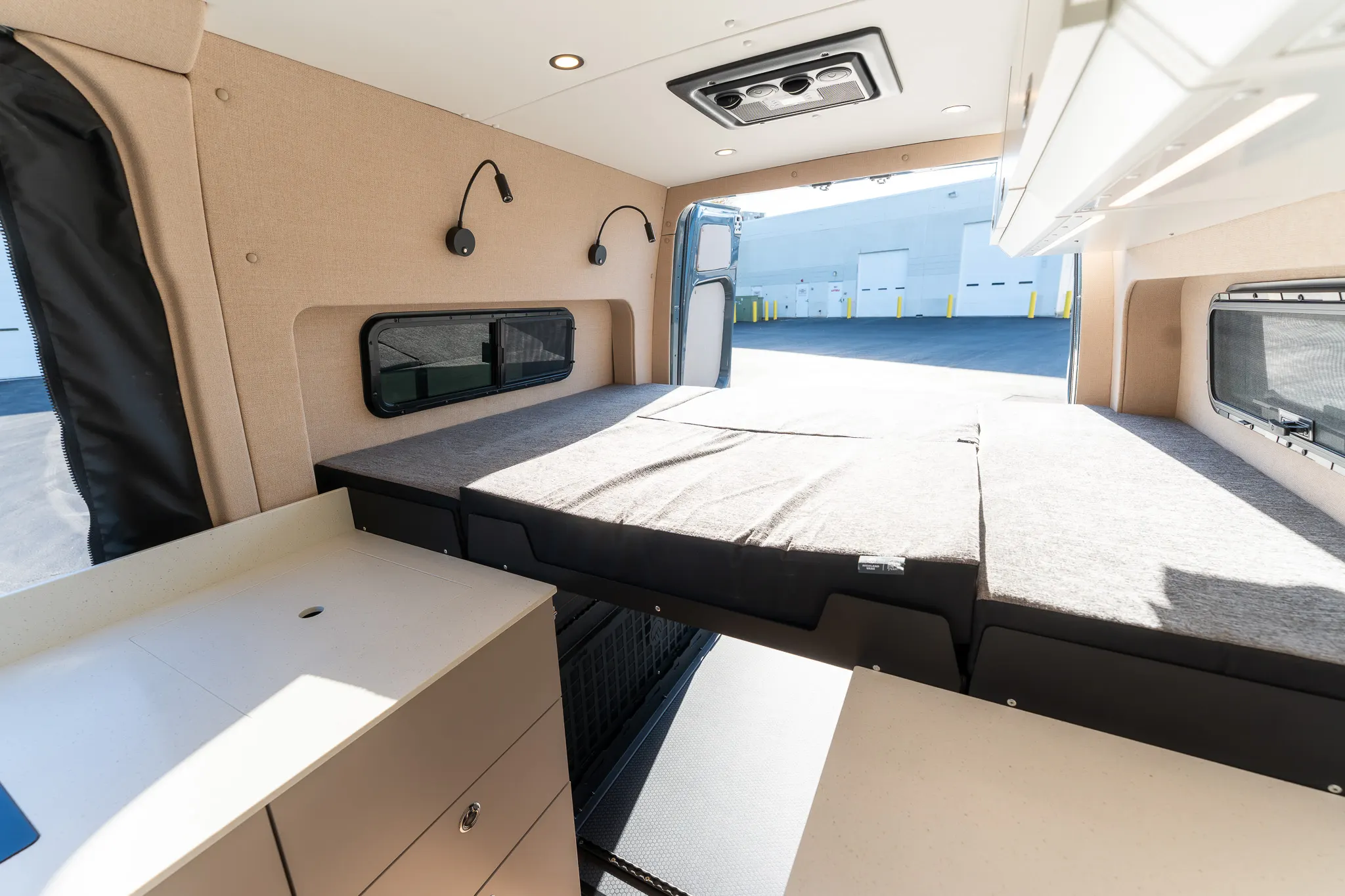 The bed made up, with reading lights and the bunk window